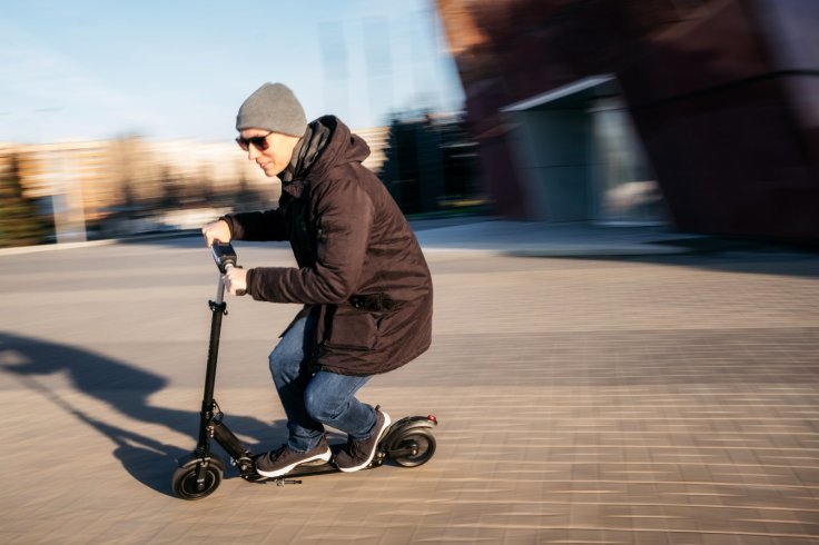 Young man on electric scooter on street